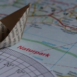 Оригами журавлик на фоне дорожного пейзажа как символ путешествий